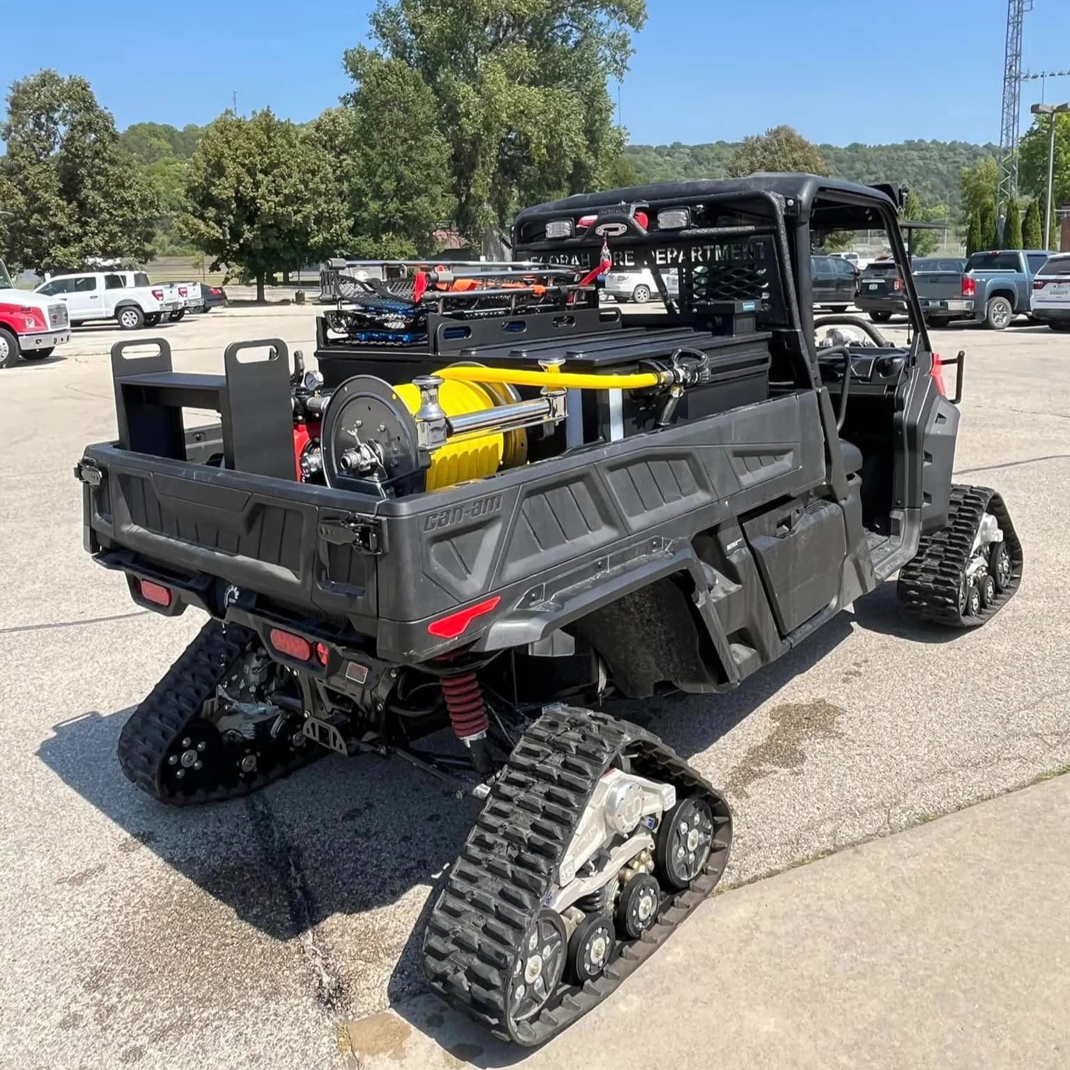 Tracked Can-Am Defender fire UTV lettered Decorah Fire Department, carrying a bed skid with a booster reel, pump, and enclosed storage boxes
