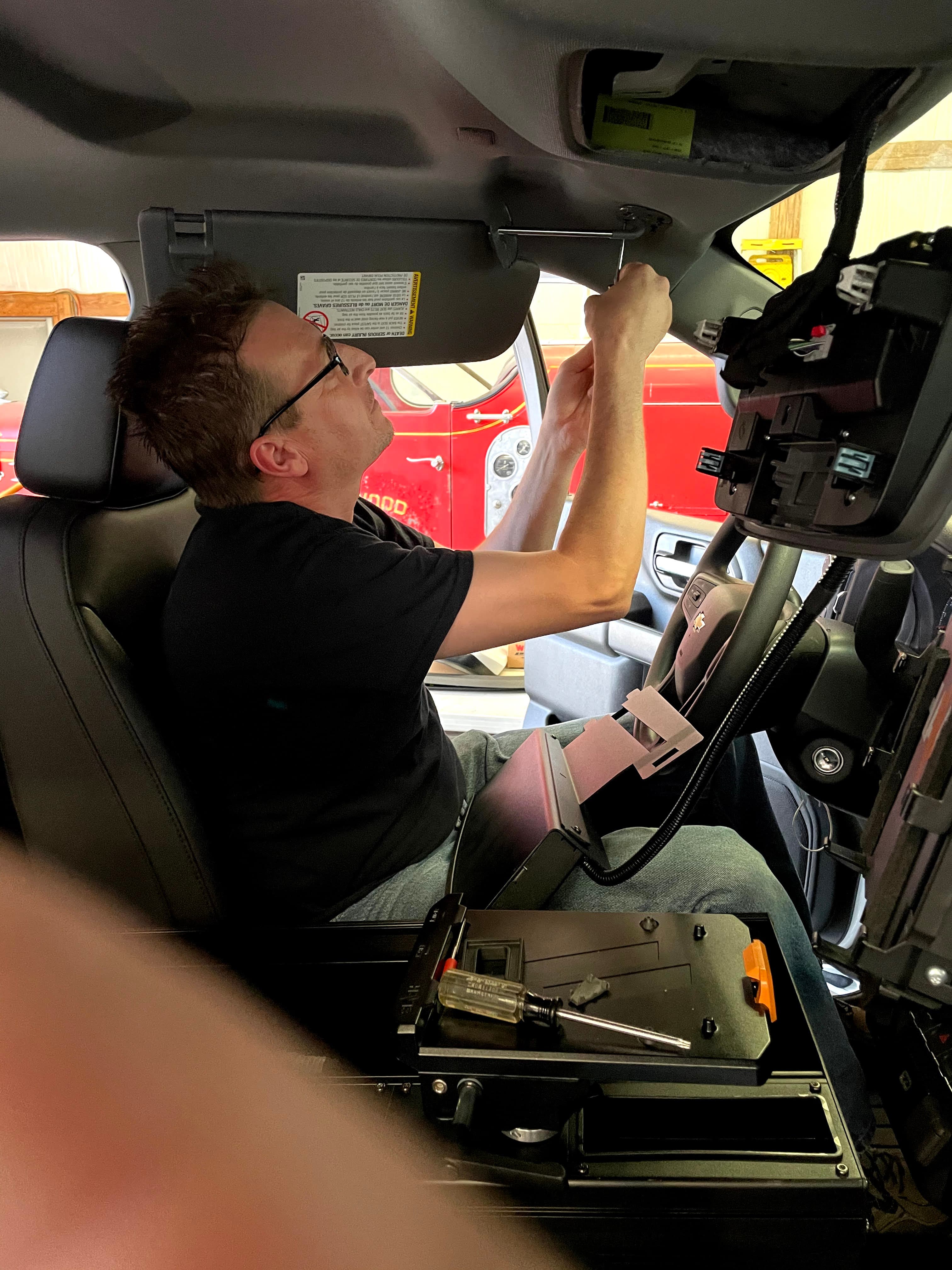 Technician servicing communication equipment inside fire apparatus