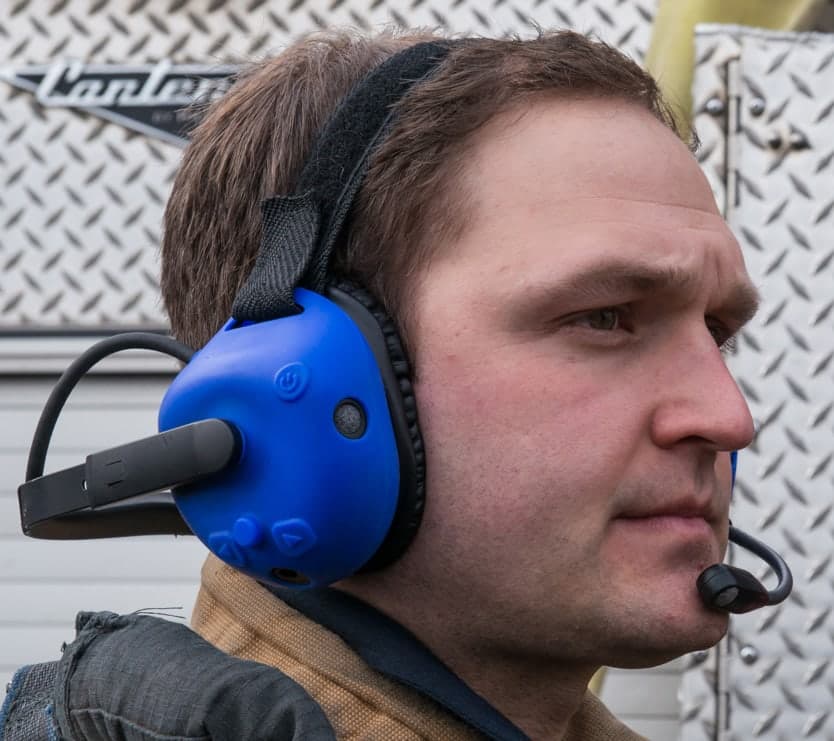 Firefighter wearing a FIRECOM 500-Series headset fitted with coloured silicone ruggedizers used to identify positions